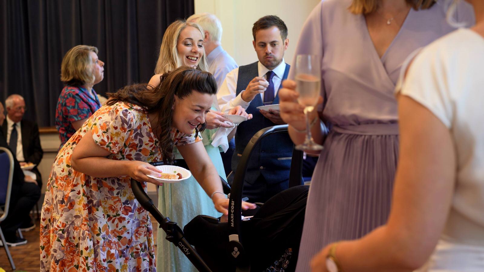guests smile at baby during wedding reception