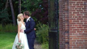 bride and groom kiss for video in Inglewood manor gardens