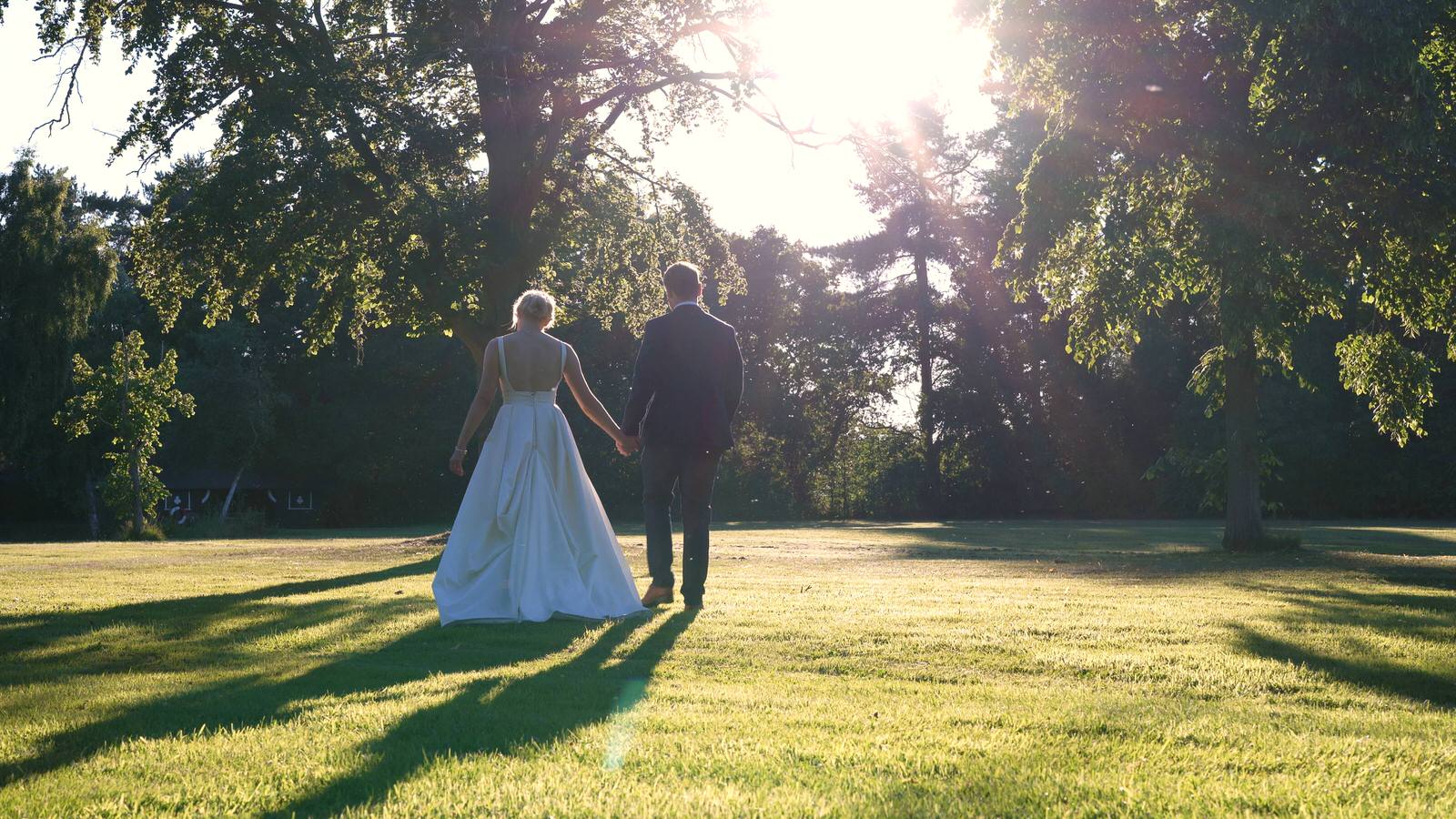 couple walk in the golden hour light for wedding videographer
