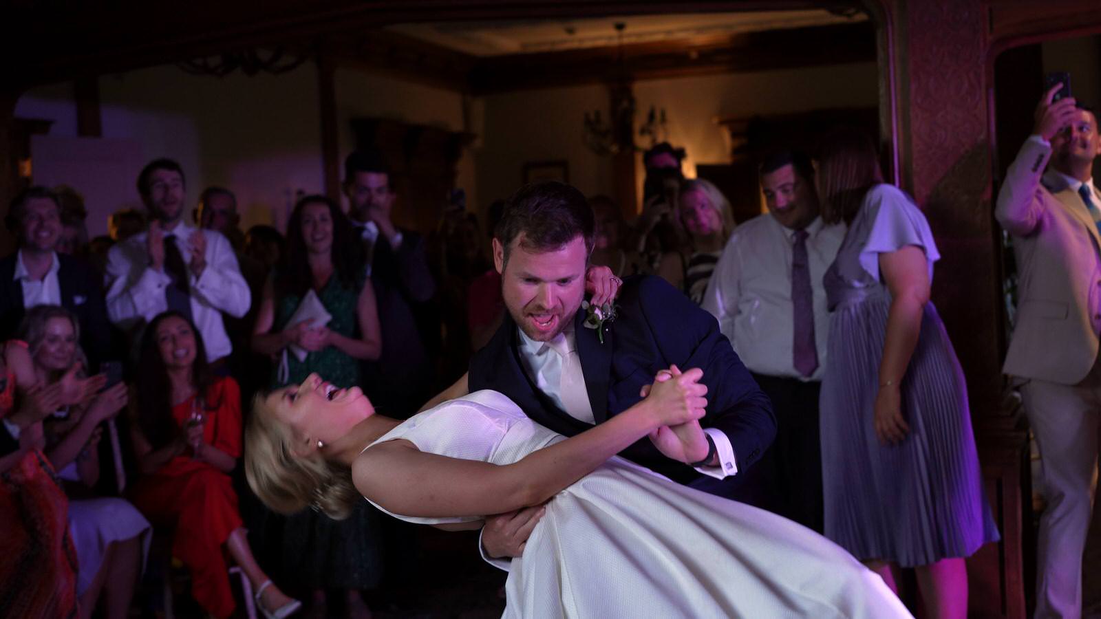 groom dips bride during fun first dance