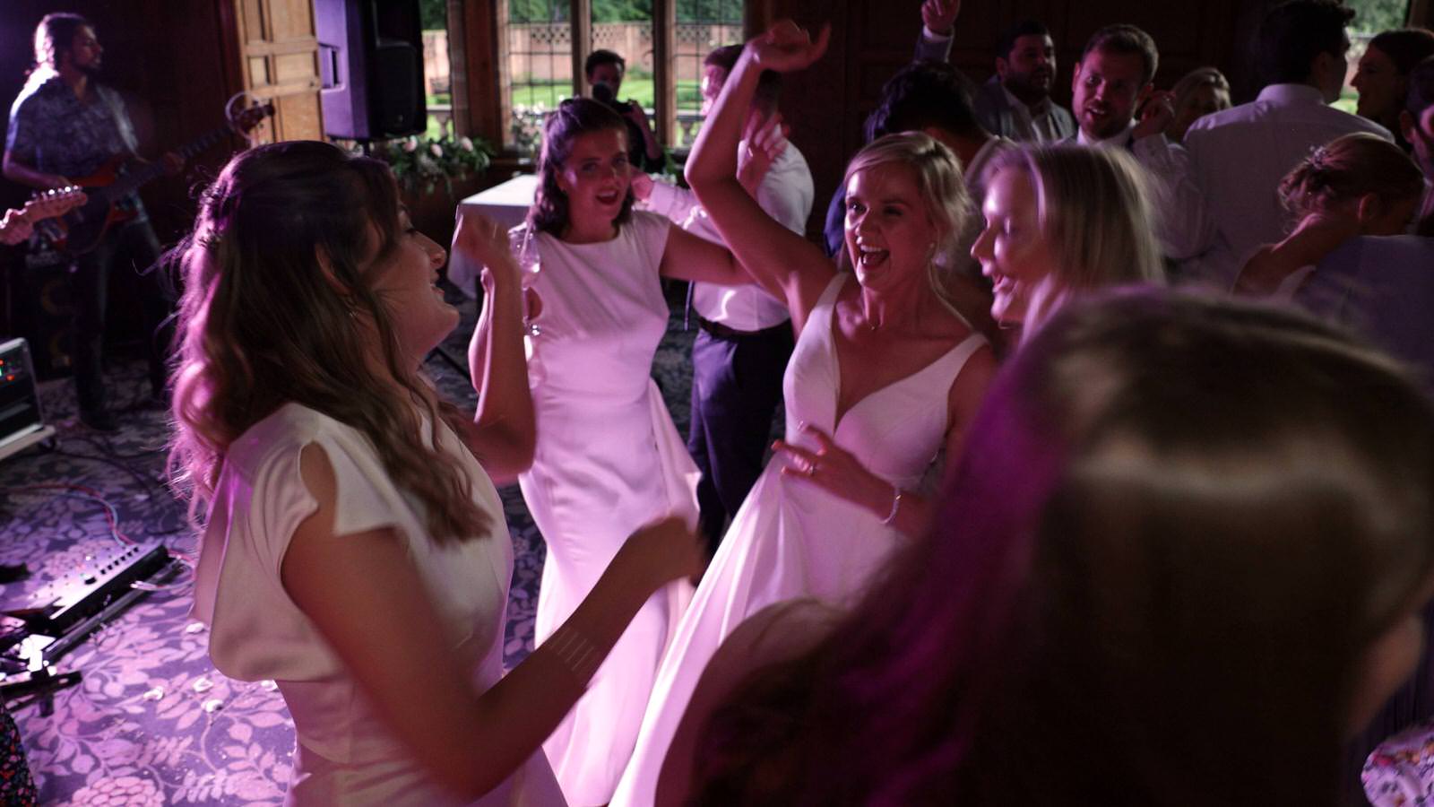 bride dances with bridesmaids at evening reception