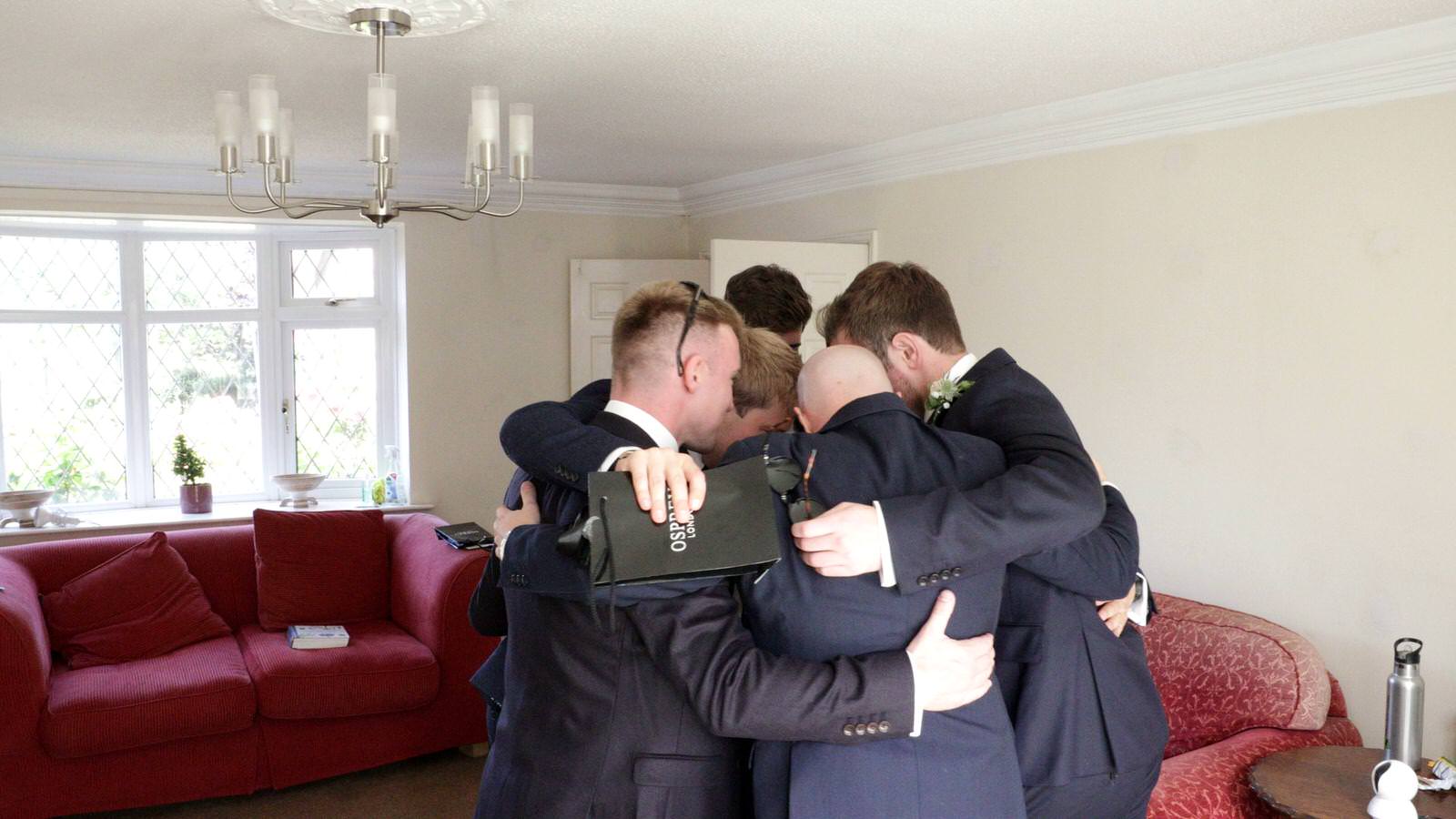 groom joins in group hug with friends