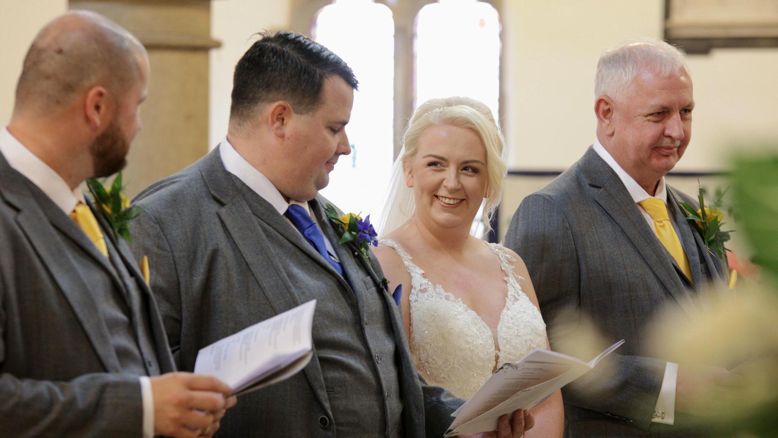 couple smile at each other during wedding service