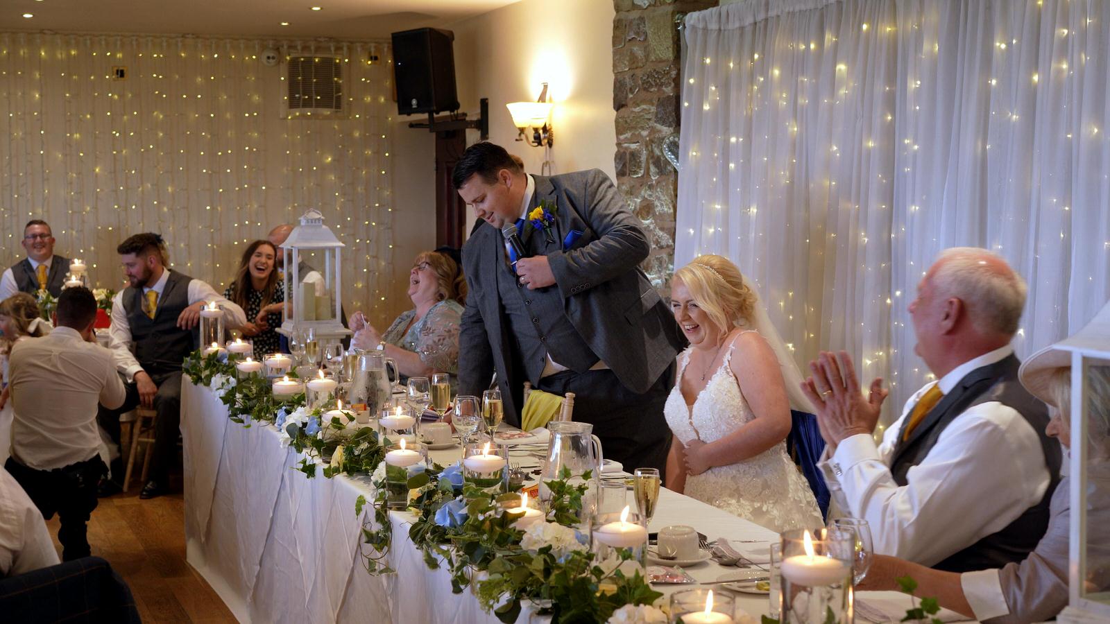 guests laugh at grooms speech