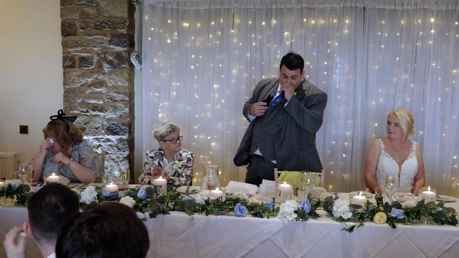 groom wipes tears away during wedding speech