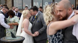 couple kiss during outside summer dancing at wedding