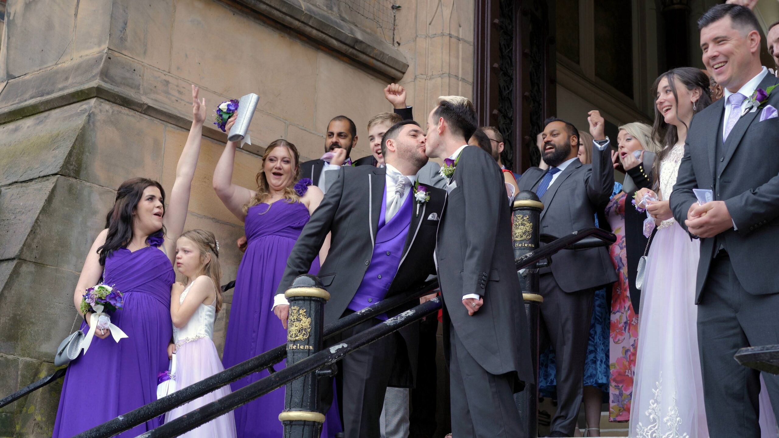guests cheer outside town hall as couple kiss