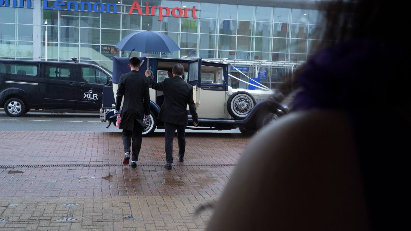 groom escorted to wedding car outside liverpool airport