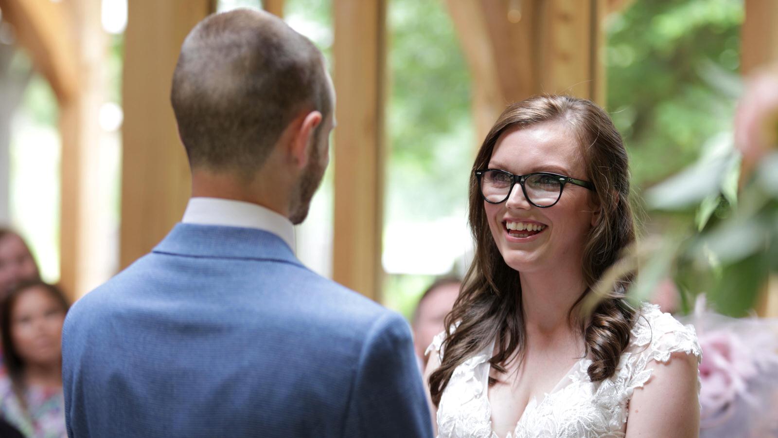 couple smile at each other during wedding ceremony