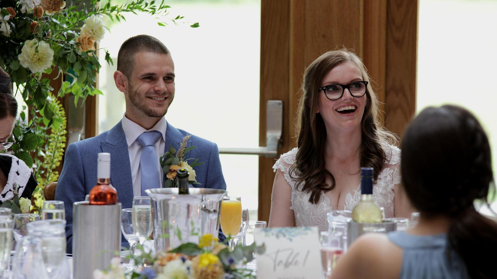 bride and groom laugh at dads speech