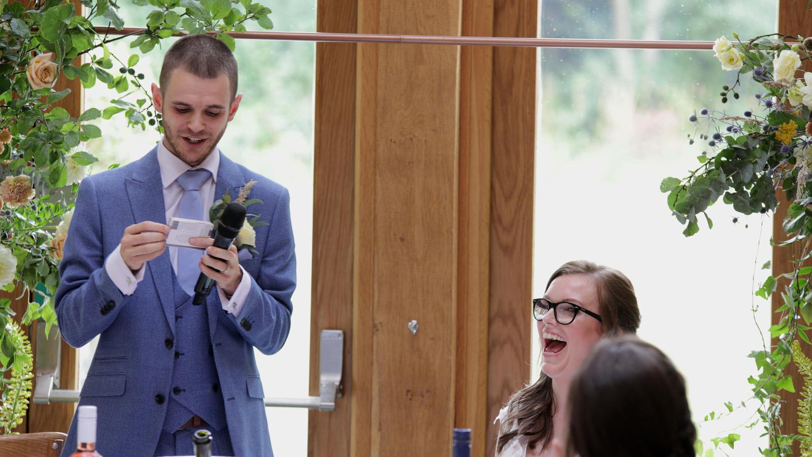 groom makes bride laugh during his wedding speech