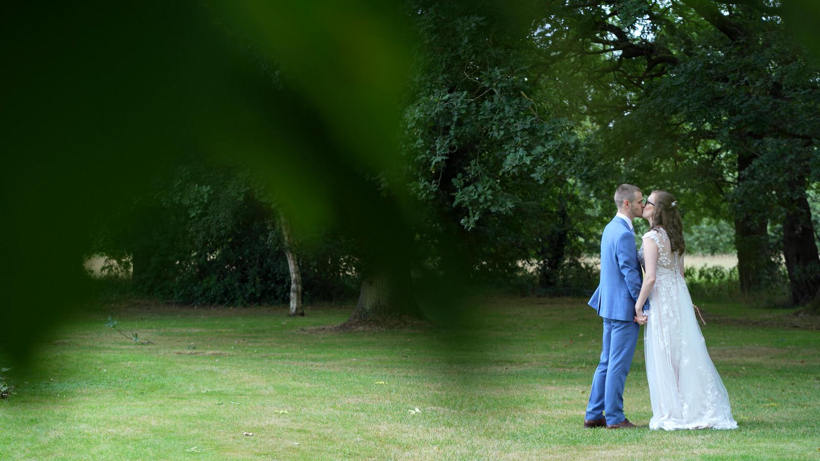 Kerry and Nicks Oaktree Peover wedding 28 natural video still of couple kissing under trees