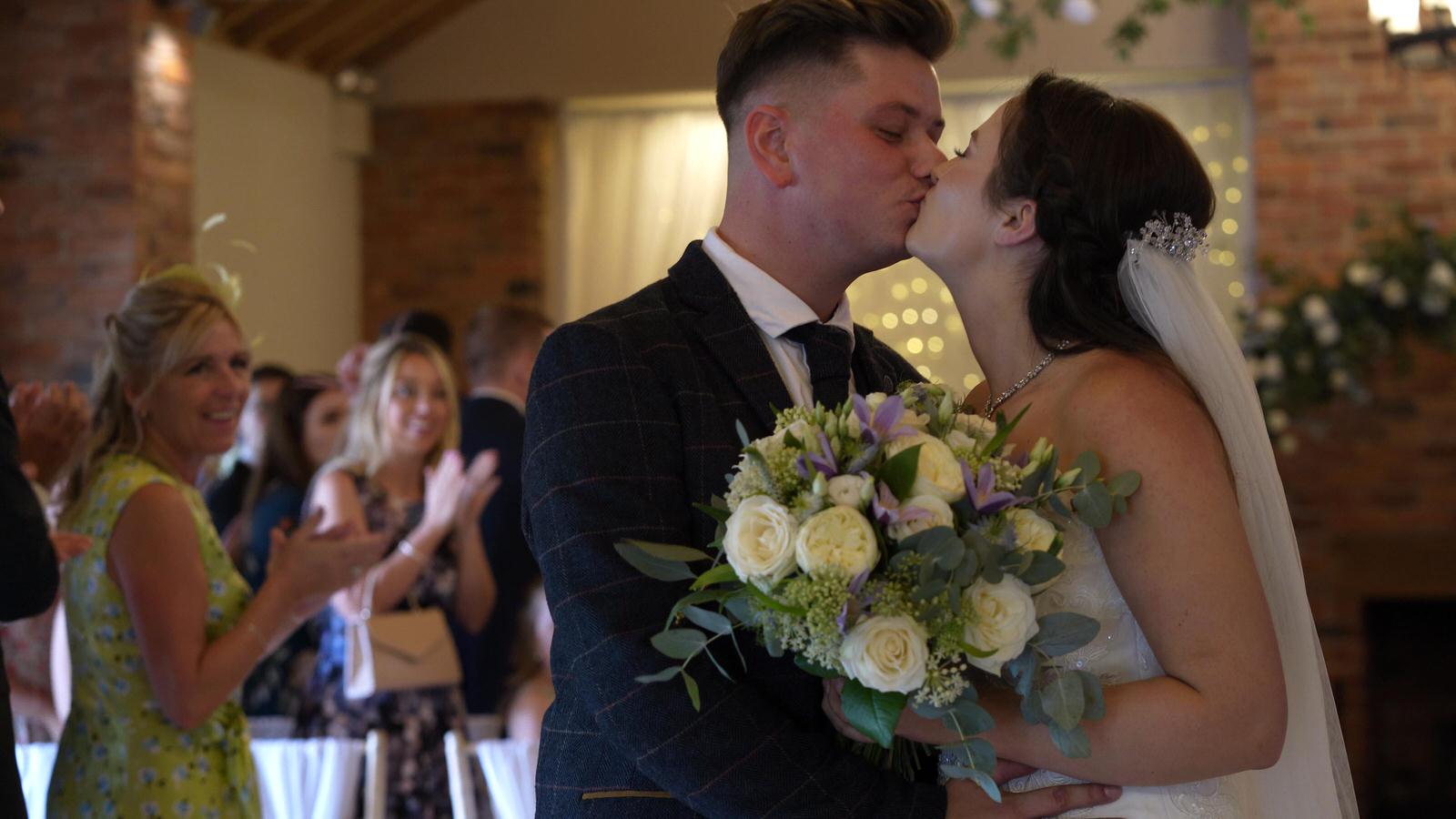 a couple kiss after getting married at Charnock Farm