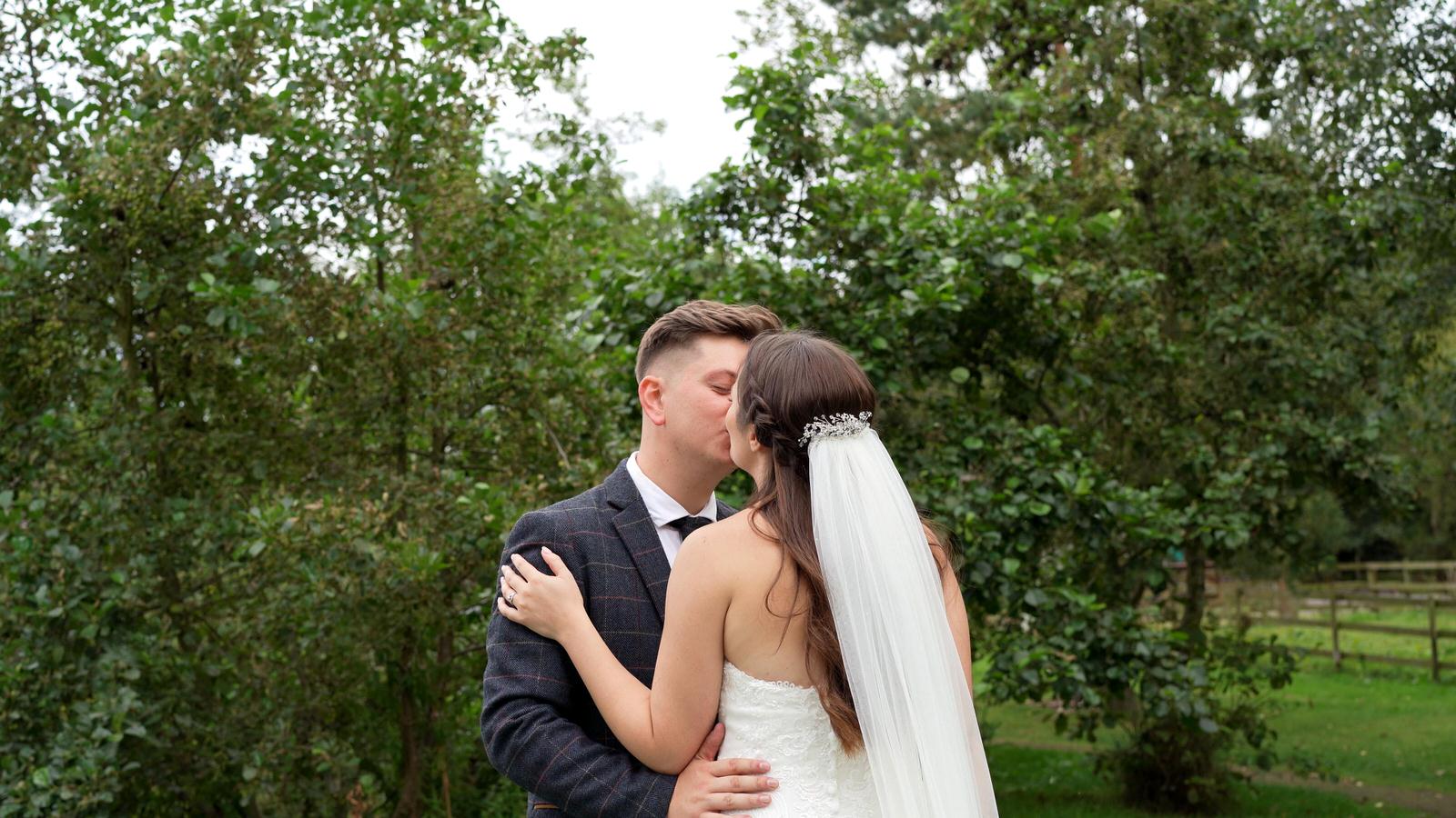 natural moment of couple enjoying a kiss by the lake at Charnock Farm