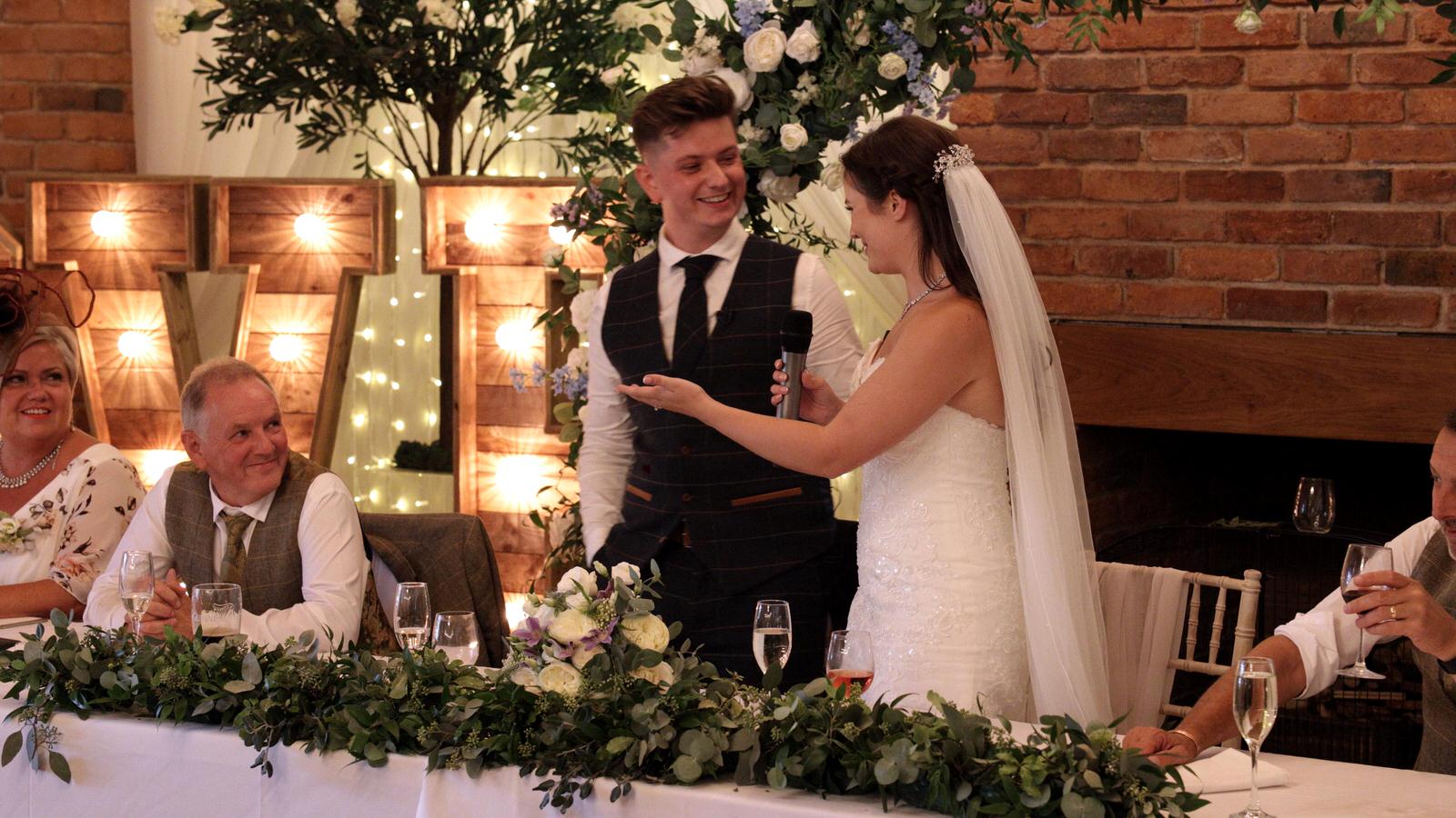 bride stands to say a few thank yous a their wedding