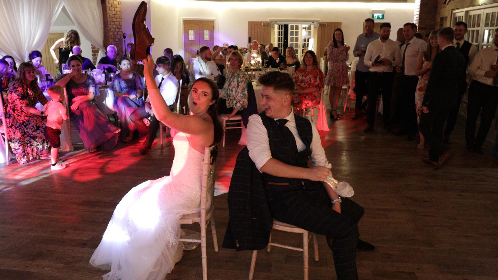 couple play a fun wedding shoe game during evening reception