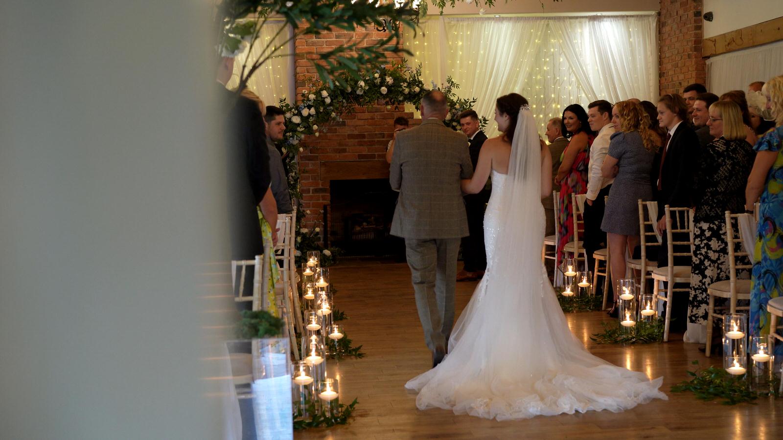 bride walks down the aisle with dad at Charnock Farm wedding