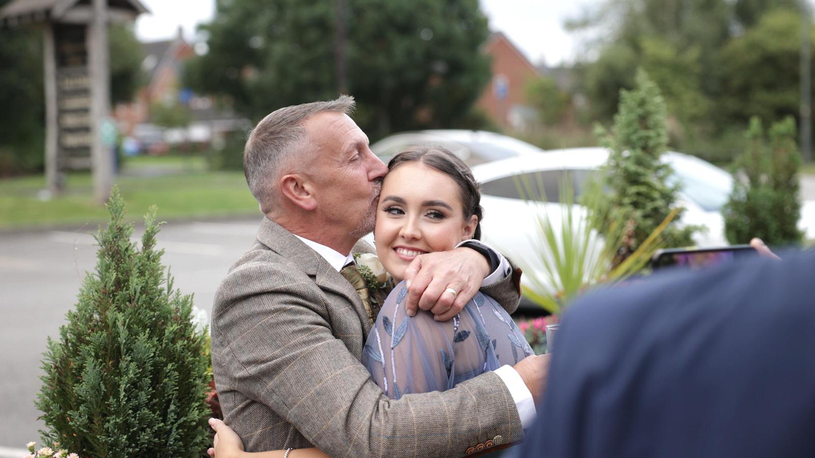 dad hugs his daughter during wedding reception