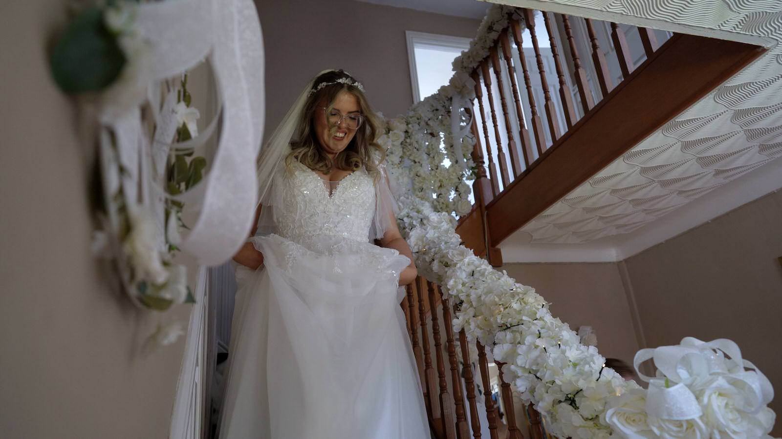 bride walks down a decorated staircase in Lancashire
