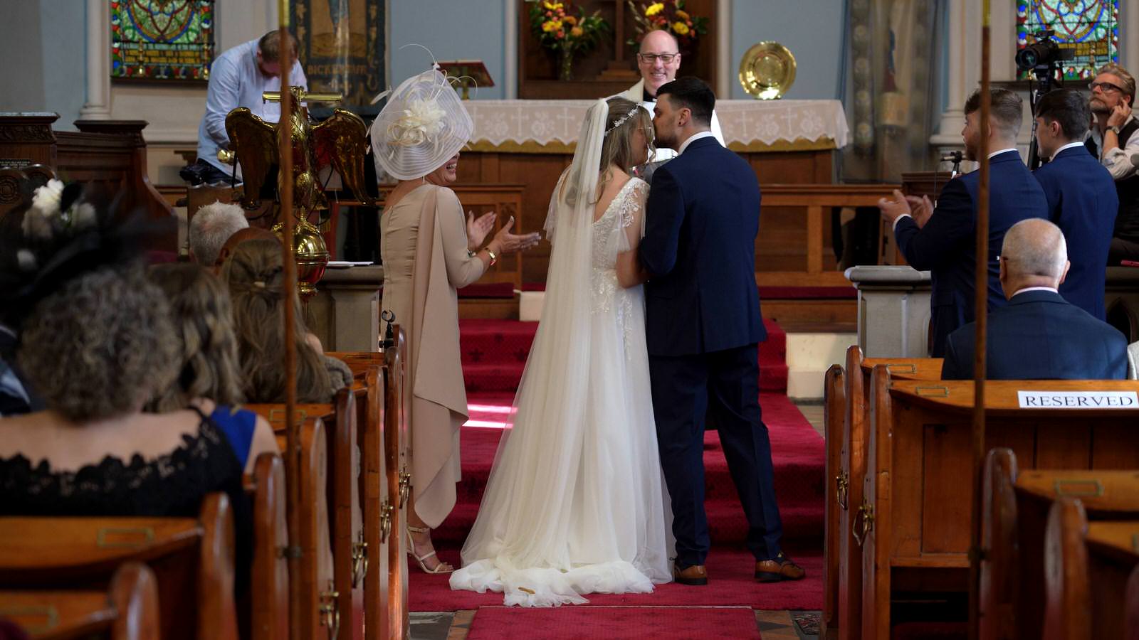 groom kisses his bride during church ceremony in Lancashire