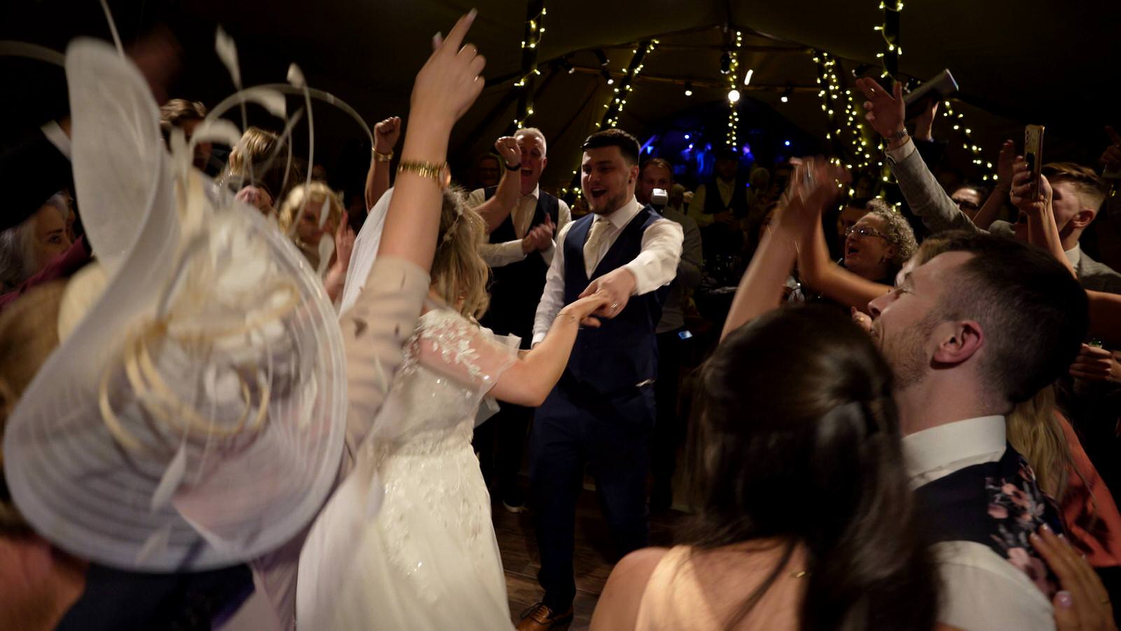 couple surrounded by singing guests for their first dance