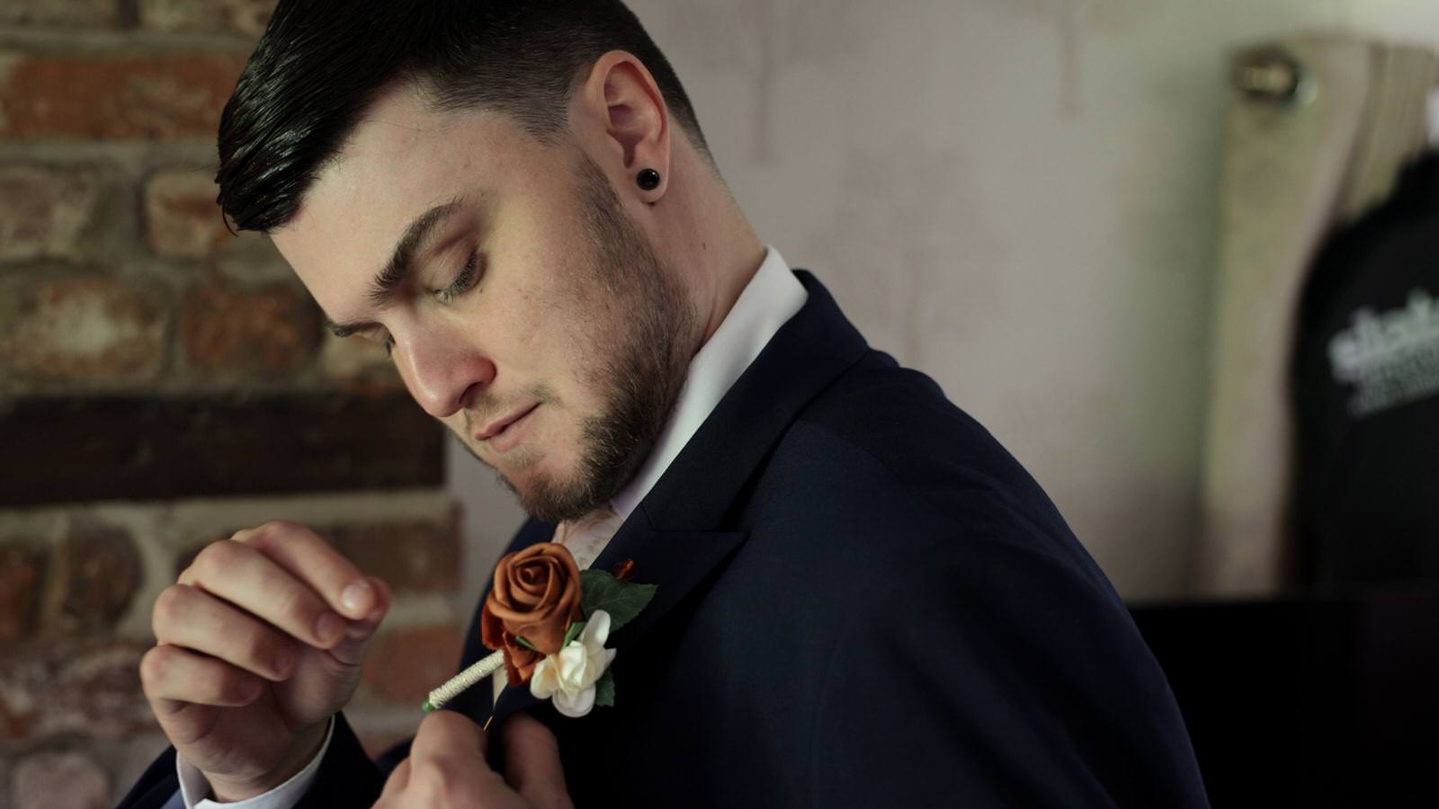 groom tries to fix his buttonhole