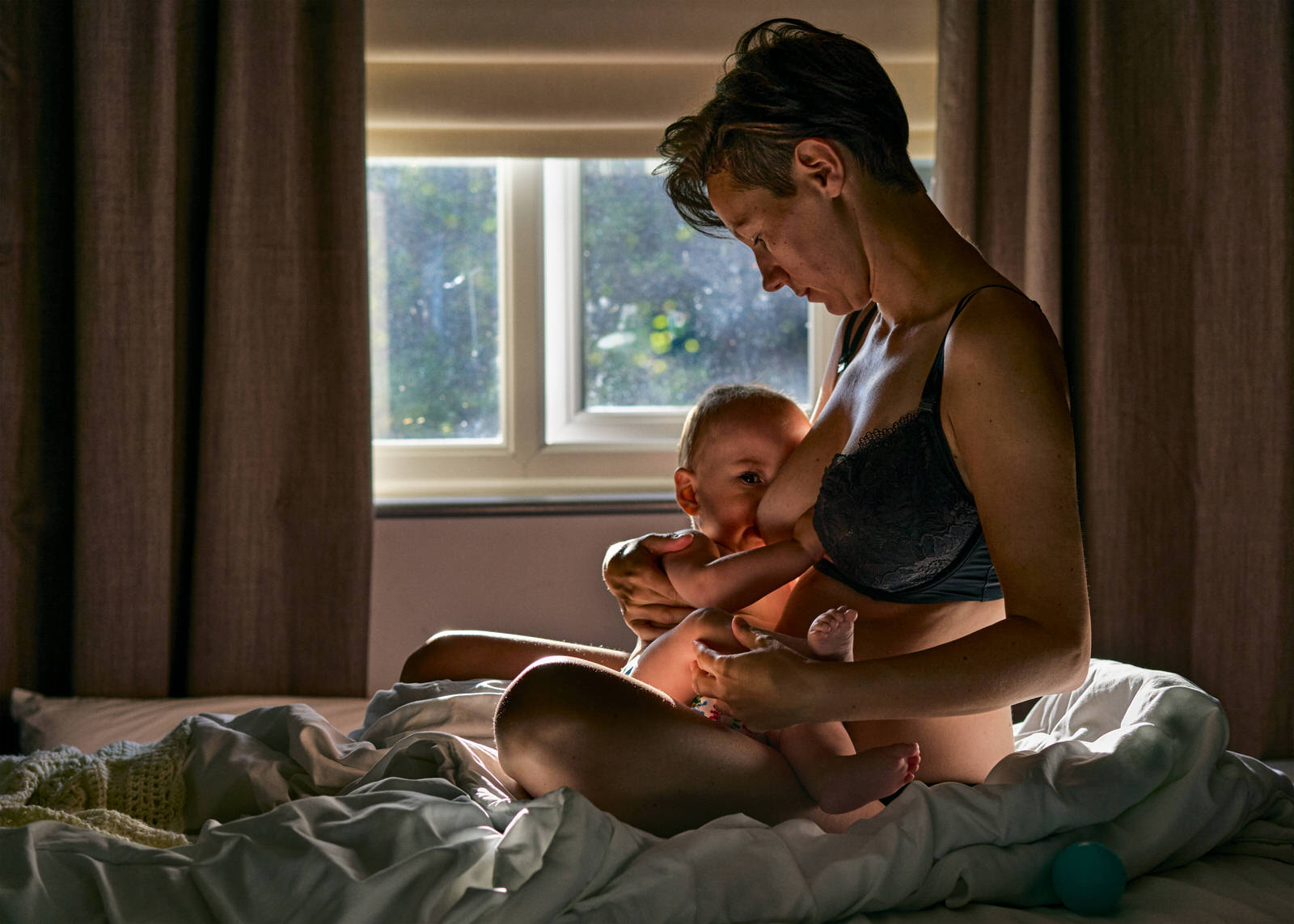 breastfeeding self portrait photo of a mother on a bed with baby