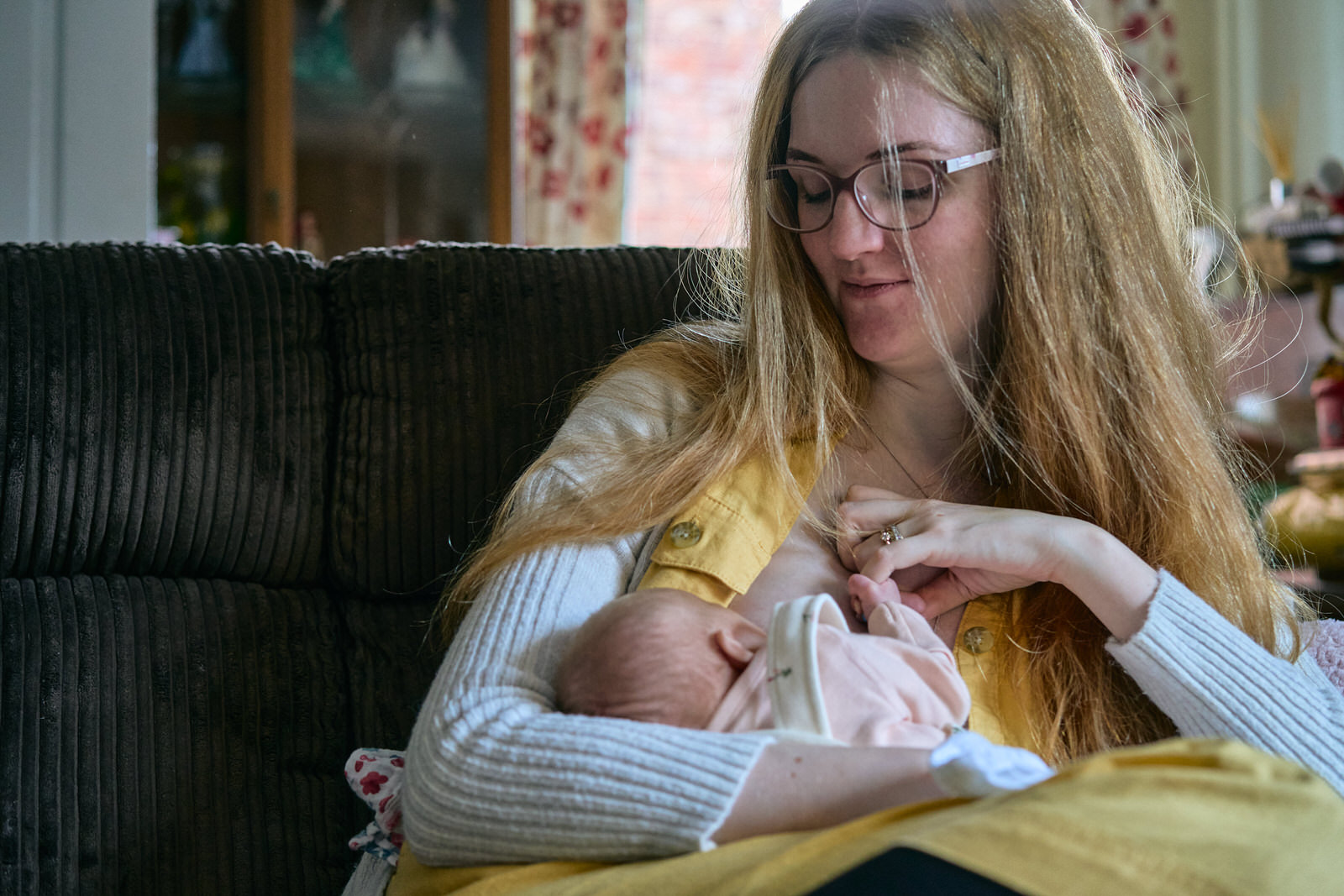 natural photo of mother breastfeeding on her sofa at home