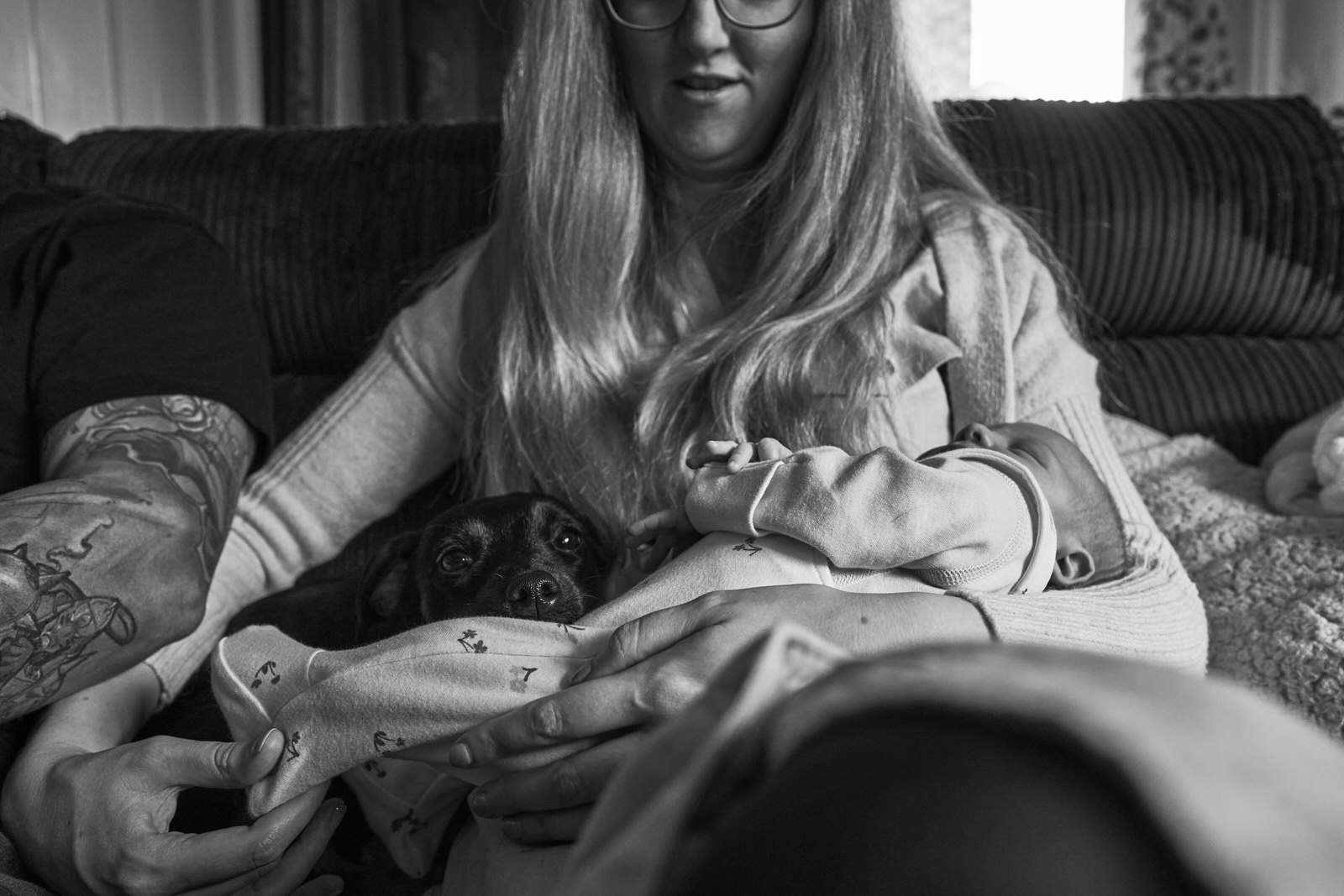 natural photo of a baby sleeping in her mothers arms at home