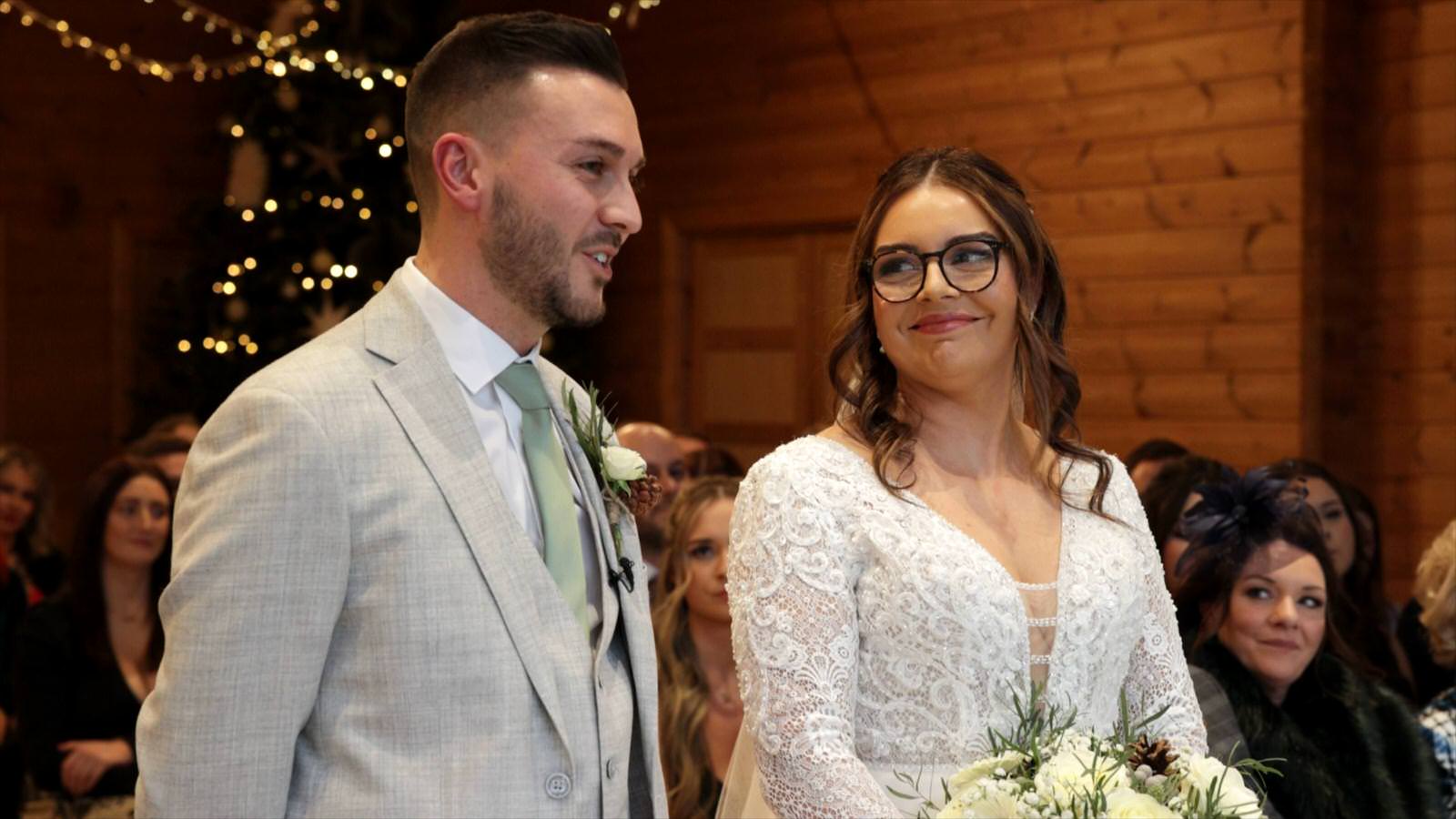 bride smiles at groom whilst he says his wedding vows