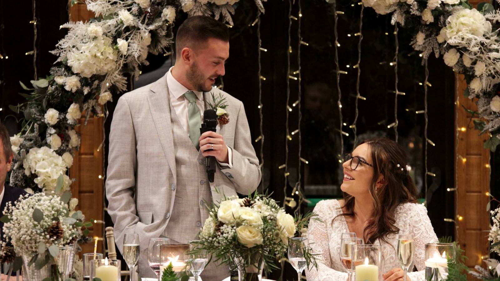 couple smile at each other during Grooms speech