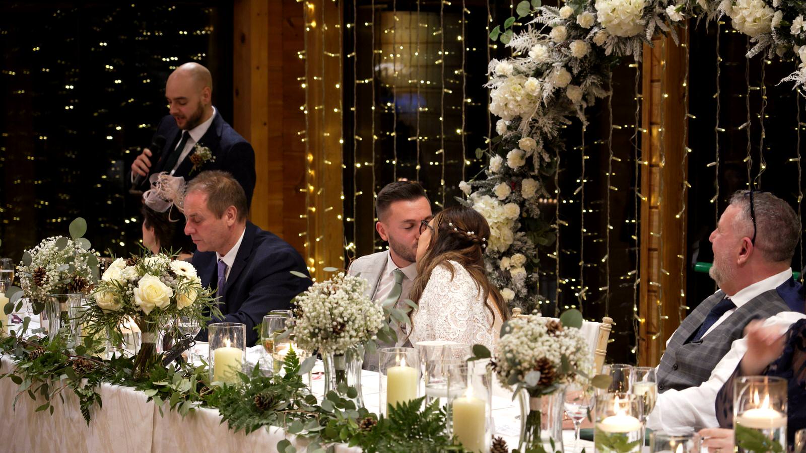 couple kiss during best mans speech at top table