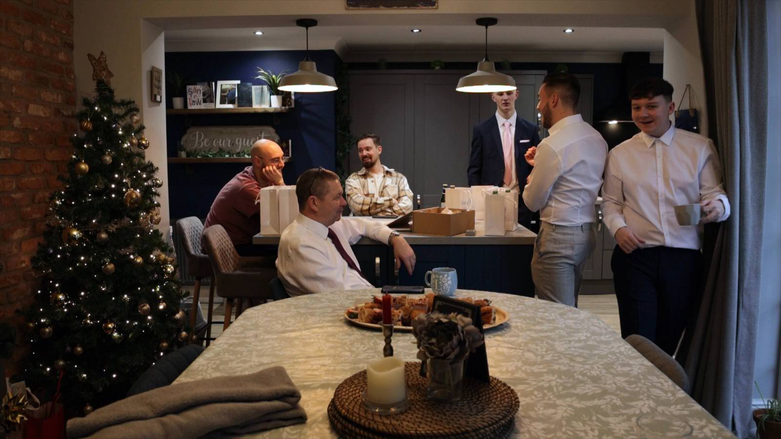 Groom and groomsmen chat at home before wedding