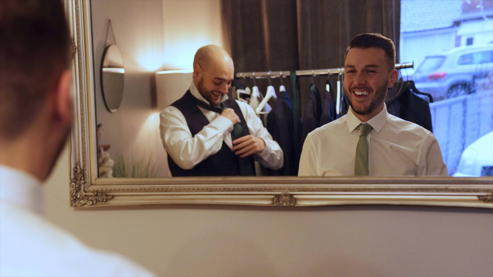 grooms reflection in the mirror laughing