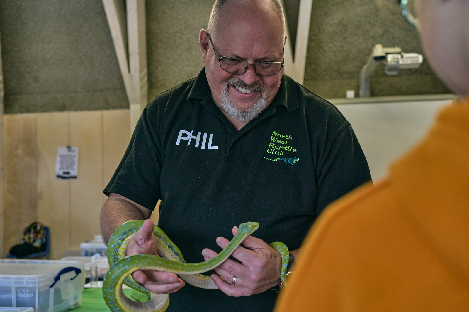 phil mellor holds a bright green snake at Brockholes