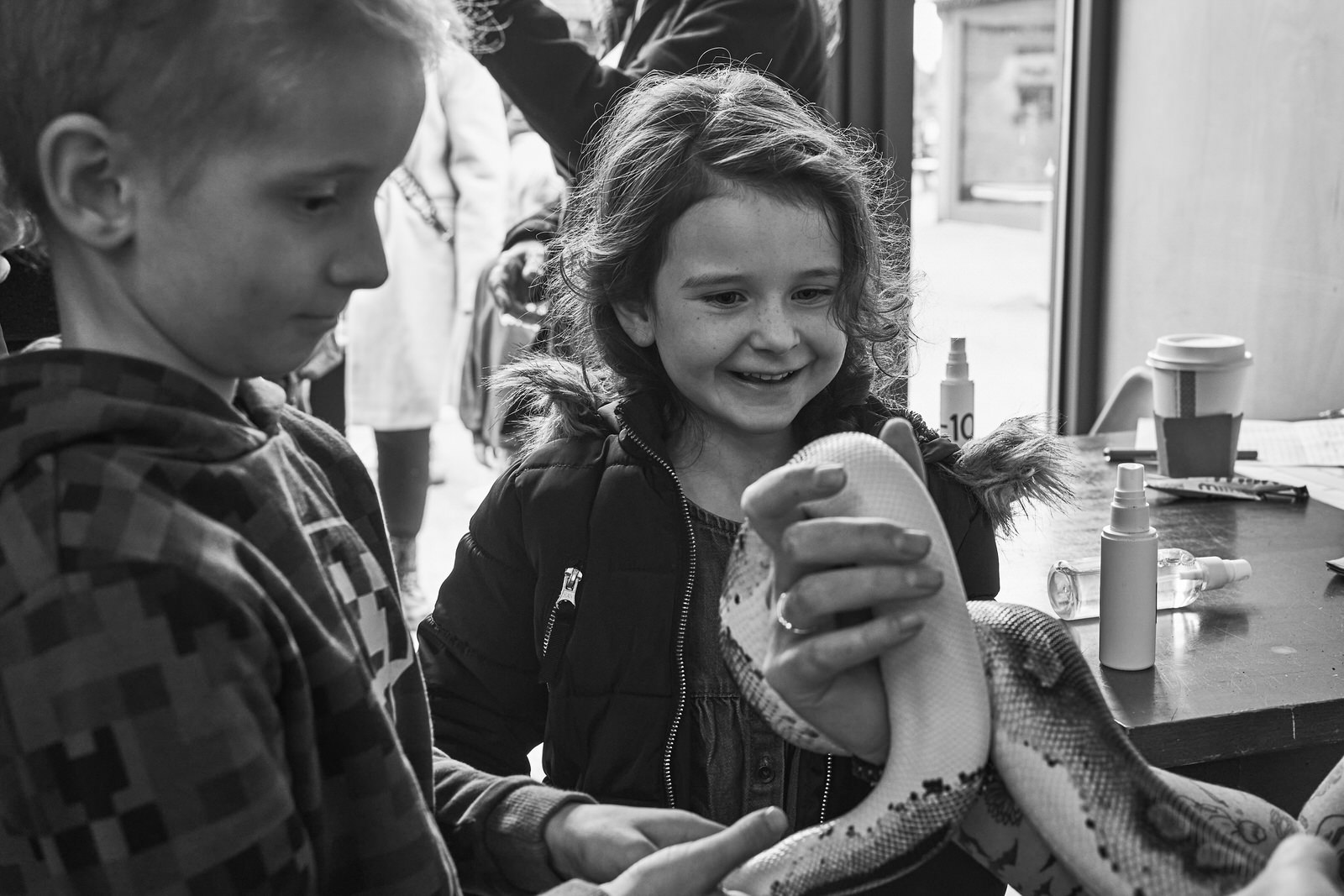 two kids smile at a royal python being displayed at Brockholes