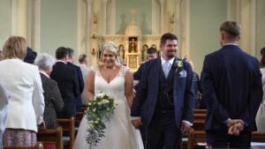 the couple smile as they leave St gregory's church married