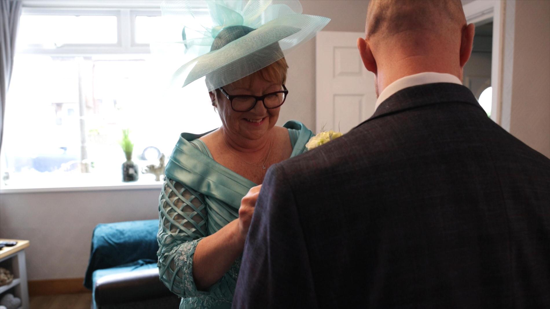 the mother of the groom tries to add a buttonhole