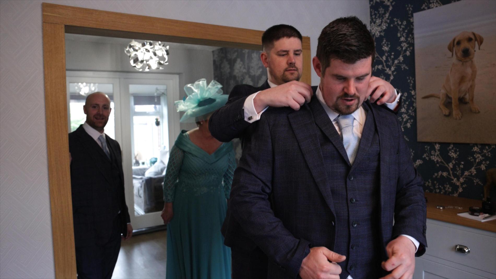 the best man sorts the grooms collar