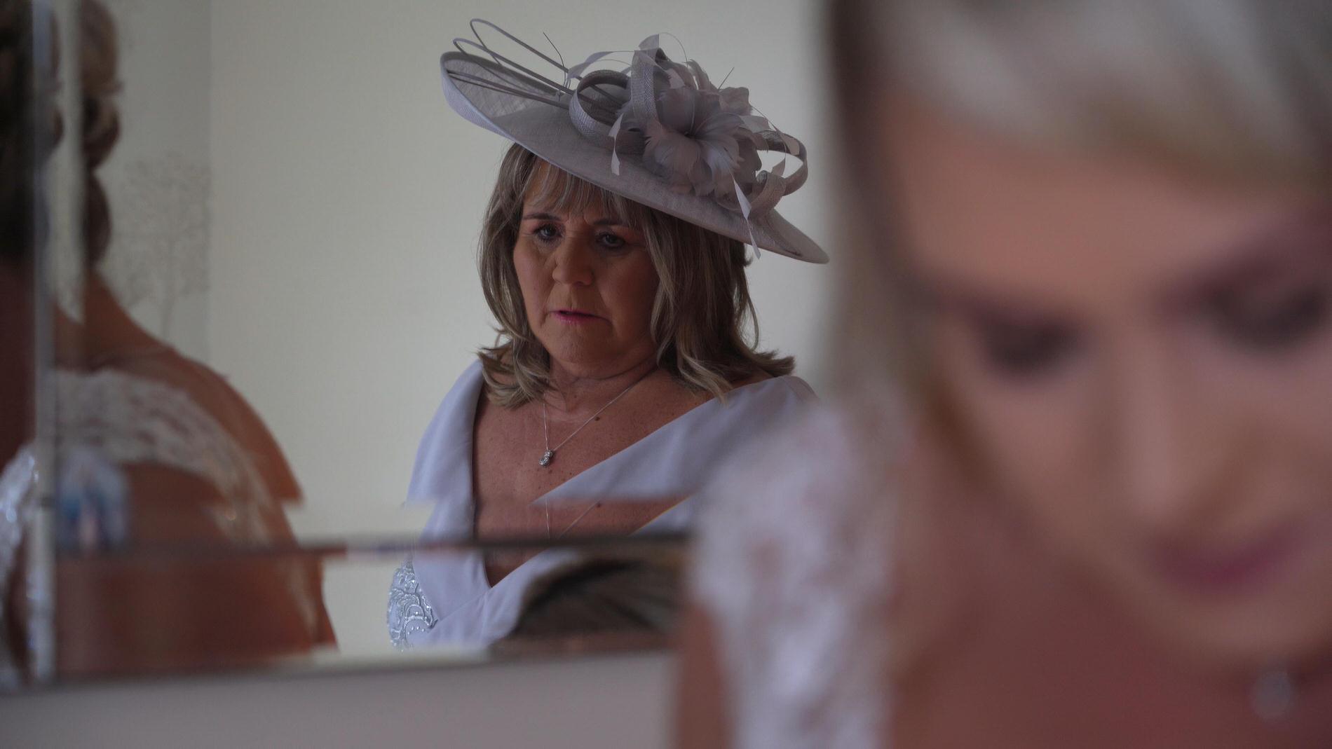 a video still of the mother of the bride in the mirror