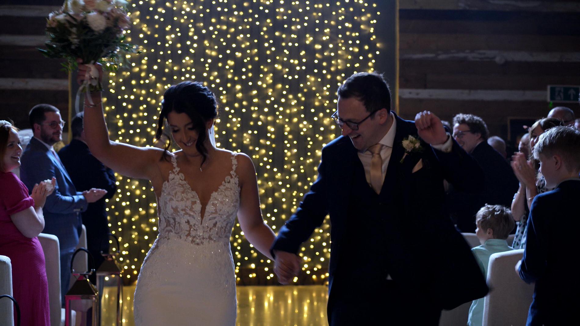 a couple dance out of the ceremony barn at Wharfdale Grange