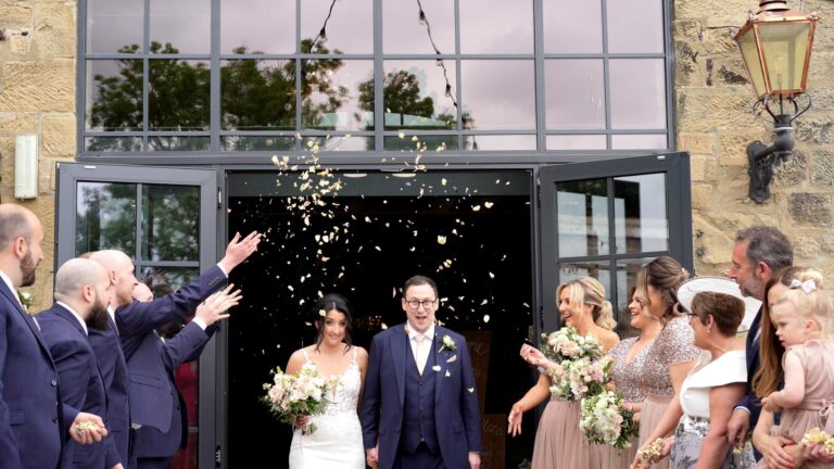 a video still of a couple walking out to confetti outside Wharfdale Grange