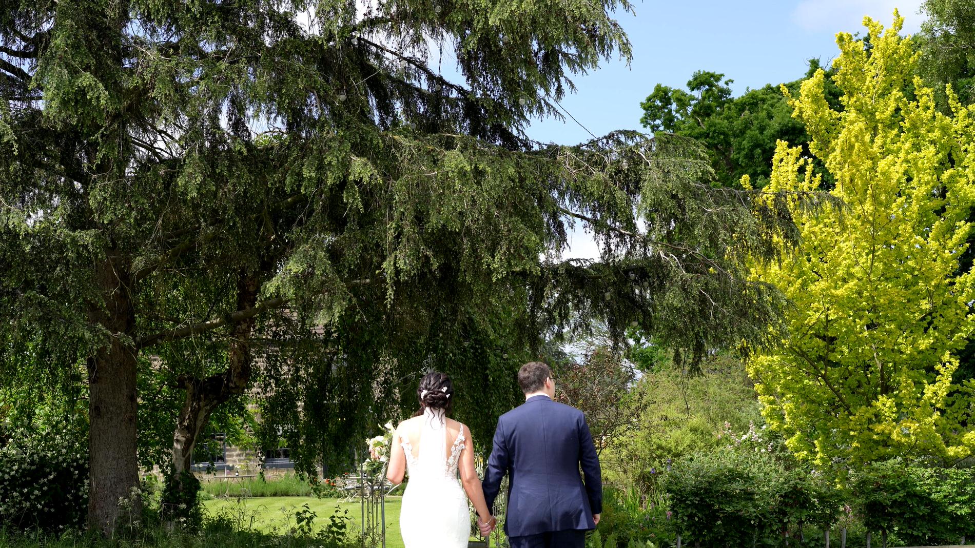 a bride and groom walk round the gardens at Wharfdale Grange in Yorkshire