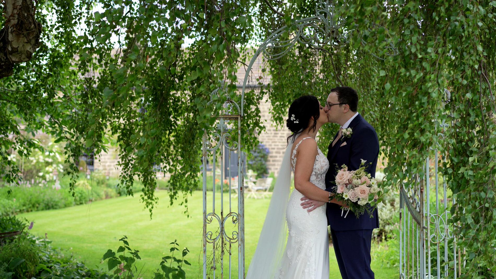 a video still of a couple kissing under a willow tree