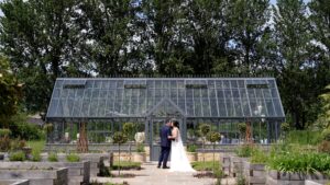 a couple kiss by the glasshouse at Wharfdale Grange in Yorkshire