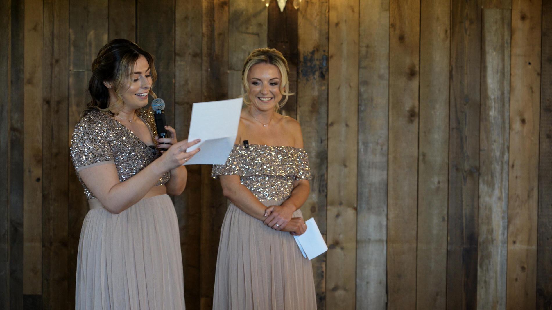 two bridesmaids stand to make a speech