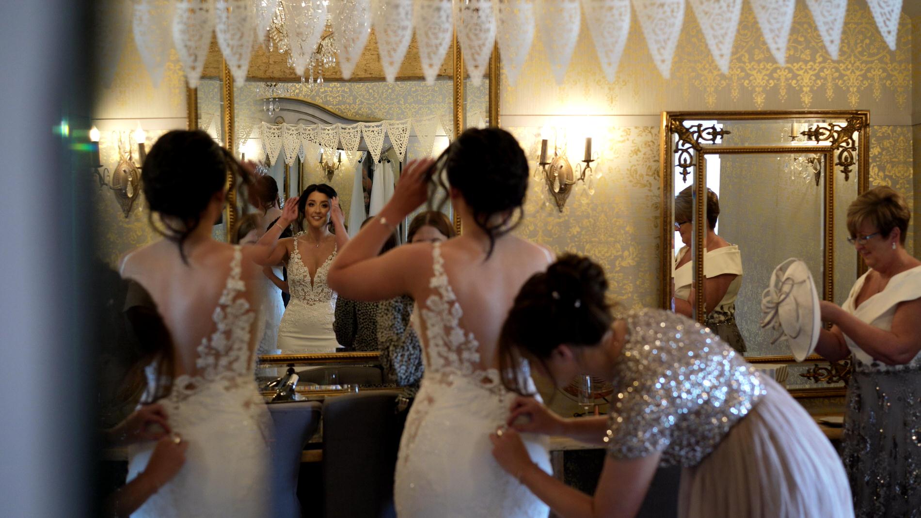 a bride is helped in to her wedding dress at Wharfdale Grange in Yorkshire