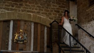 a bride walks down the stone barn steps at Wharfdale Grange