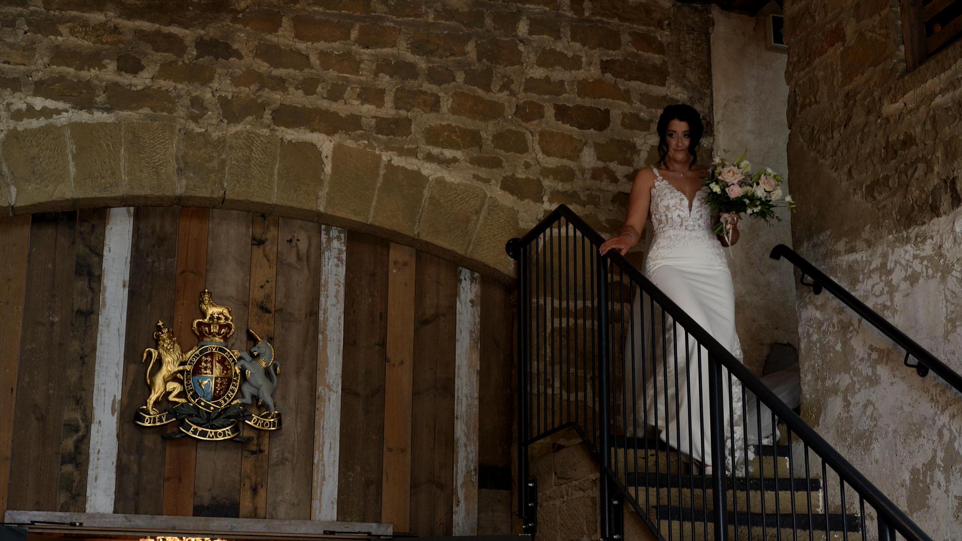 Courtney Dan Wharfdale Grange Wedding Video 6 a bride walks down the stone barn steps at Wharfdale Grange
