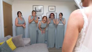 an emotional reaction from the bridesmaids seeing the bride